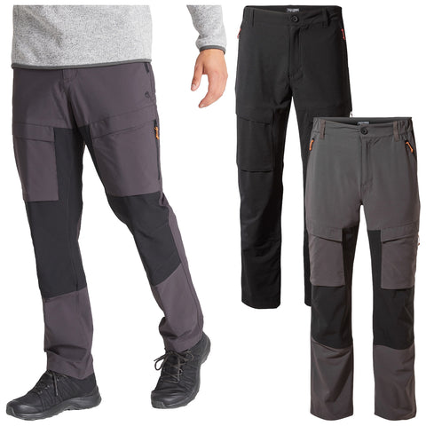 Three pairs of outdoor pants are displayed with one being worn by a person. Each pair features multiple pockets and a combination of black and gray colors designed for active use.