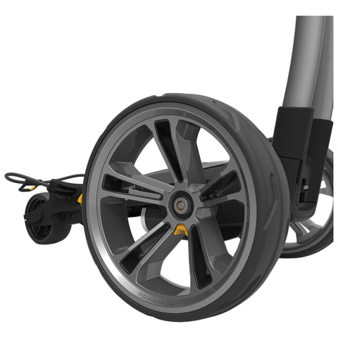 A gray stroller wheel is positioned prominently showing sleek spokes and a rubber tire while connected to the stroller frame highlighting its lightweight and modern design in a neutral setting.