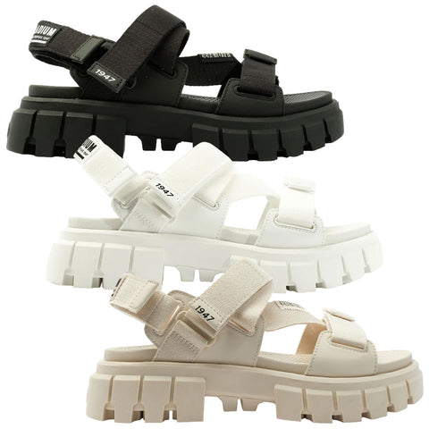 Three pairs of chunky sandals are displayed vertically. Each pair features adjustable straps and thick soles with defined treads. The colors are black, white, and light beige.