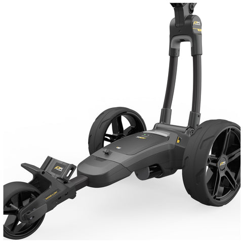 A sleek black golf push cart with large wheels is positioned upright featuring a curved handle and a compartment for accessories highlighting a modern design suitable for outdoor use.