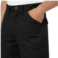 Black pants are worn with a hand placed in the pocket displaying a casual stance against a neutral background. The waistband features a button and belt loops for fitting.