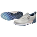 A light gray golf shoe is displayed with a functional lace system featuring a dial and a textured outsole designed for grip and traction in outdoor settings.