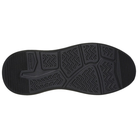 A black shoe sole rests flat on a surface showcasing its textured grip pattern designed for traction while highlighting its curvature and contours in an indoor setting.