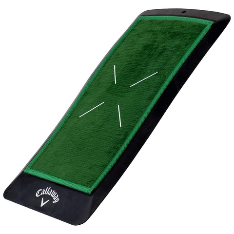 A golf putting mat is positioned at an angle with a textured green surface and white markings indicating target areas surrounded by a black border for indoor practice