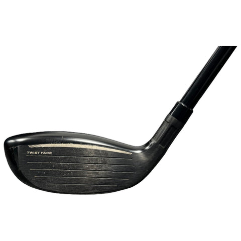 A black golf club head is positioned facing upward showcasing its smooth surface and textured underside suggesting readiness for hitting a golf ball in a sports context.