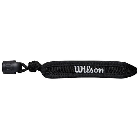 A black racquet strap is laying flat with the word "Wilson" in white embroidery on one side while a rubber cap is attached at one end showing it is designed for securing equipment.