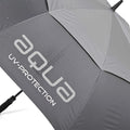 A gray umbrella with water droplets on its surface displays the text aqua UV-PROTECTION while lying flat on a surface indicating it's been recently used in wet conditions.