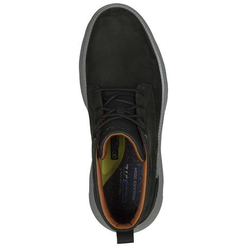 A dark green shoe with a sleek design is positioned upright showcasing its laces and textured interior in a neutral setting that emphasizes its modern style and comfort features