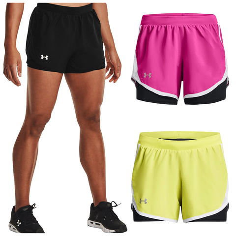 Black athletic shorts are worn by a person standing with bare legs while pink and yellow shorts are displayed nearby on a neutral background showcasing various colors and styles of activewear.