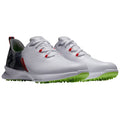 White sports shoes with a textured upper and red accents sit on a plain background showcasing a modern design suitable for athletic use with a green spiked sole for traction.