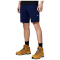 A person stands wearing navy shorts and brown hiking boots. They are outdoors, likely engaged in an activity requiring comfortable and durable clothing suitable for hiking or outdoor exploration.