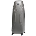 A tall silver suitcase stands upright on four wheels showcasing a sleek design with smooth curves and a rounded top ready for travel in an indoor setting.