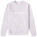 A light purple sweatshirt is displayed featuring the word Humanrace in bold white letters across the chest positioned against a plain background highlighting the garment's soft fabric and minimalist design