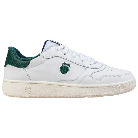 A white sneaker with green accents sits stationary showcasing a smooth leather upper laced securely and featuring a logo badge on the side against a plain background.