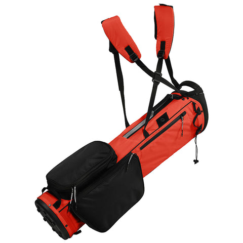 A red and black golf bag with shoulder straps contains multiple pockets for storage and is designed for carrying golf clubs and accessories during play on a golf course.