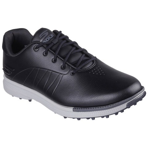 A black golf shoe with textured leather and a white sole features laces at the front and small rubber spikes underneath, suitable for outdoor golf play.