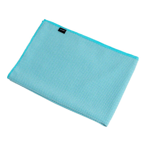 A turquoise rectangular cloth with a textured surface features white polka dots and a contrasting border. It is laid flat against a neutral background.