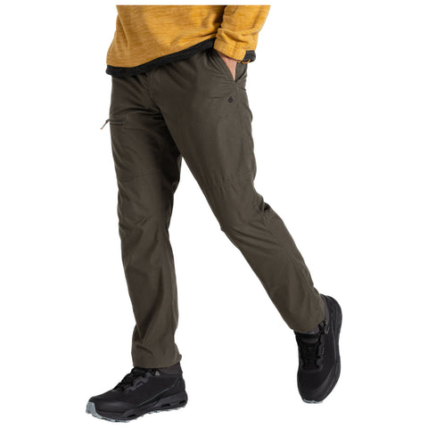 A person walks confidently wearing olive green pants and black hiking boots complemented by a mustard sweater in an outdoor or casual setting.