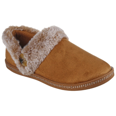 A brown slip-on slipper features a soft fur trim and a decorative button. It is designed for comfort and warmth, suitable for indoor use on various surfaces.