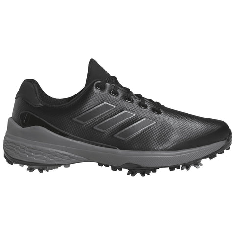 A black golf shoe features a textured upper with three iconic stripes and a grey sole, designed for enhanced traction on the course with visible spikes on the bottom.