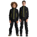 Two children stand side by side wearing matching black outdoor jackets and pants with yellow zippers smiling at the camera in a neutral background suggesting an outdoor setting.