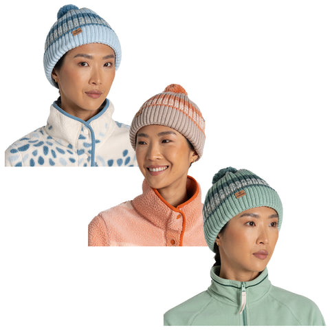 Three women are wearing brightly colored knit beanies in various styles and designs, smiling while dressed in cozy fleece jackets against a neutral background.