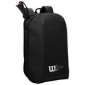 A black backpack is upright with a smooth surface featuring a logo and a signature. It is designed for carrying items and is set against a neutral background.