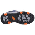 A shoe sole featuring large rubber lugs for traction sits on a flat surface showcasing a primarily black and gray design with orange accents highlighting key sections for grip and durability.