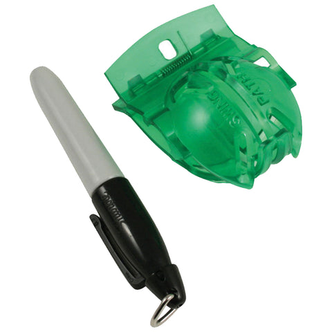 A black and white pen rests beside a transparent green pen holder designed to secure it in place both lying on a flat surface in a neutral setting