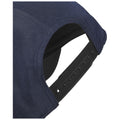 A navy cap is shown with a flexible adjustable strap at the back featuring multiple holes for size adjustment emphasizing its practicality for different users.