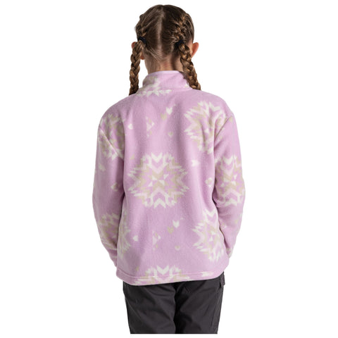 A girl is wearing a light purple fleece jacket with a decorative pattern while standing with her back to the viewer in an unspecified indoor or outdoor environment.