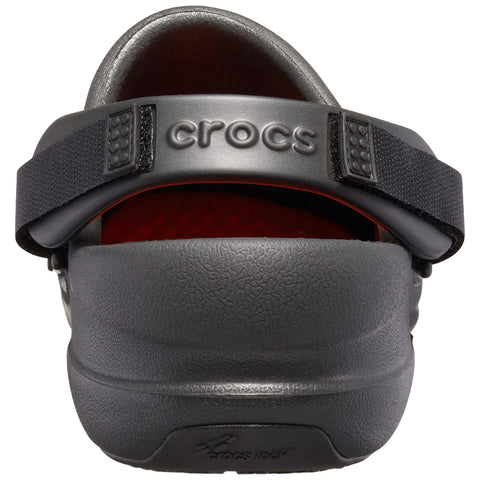 A black Crocs shoe is positioned upright showing the back view the shoe features a stretchy black strap and a textured rubber surface with a red interior.