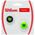 Two tennis vibration dampeners are displayed in a clear packaging. One is black with a green logo and the other is green with a black logo. The packaging features a red and white design.