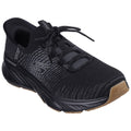 A black athletic shoe features a textured upper with a lace-up design the sole displays a patterned tread suited for various surfaces set against a plain background.