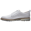 A white golf shoe sits on a flat surface featuring a smooth leather upper and a patterned sole designed for grip on grass while providing stability during a swing.