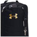 A black bag with a gold Under Armour logo contains a smartphone in a zippered pocket a key hangs from a carabiner attached to the bag's side.