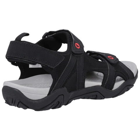 A black sandal with adjustable straps features a cushioned sole and a rugged tread design suitable for outdoor activities resting against a plain background.