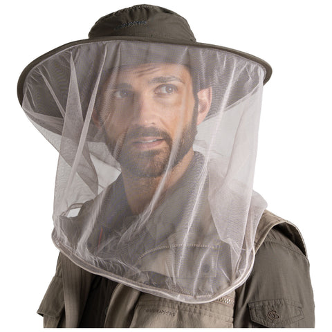 A person wearing a wide-brimmed hat with a protective mesh face shield looks forward while dressed in a light-colored outdoor jacket in a neutral background.