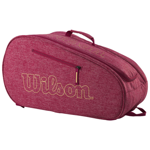 A red and textured tennis racquet bag with a prominent gold "Wilson" logo is displayed, featuring a zippered compartment and a handle for carrying in various environments like courts or storage.