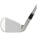 A golf club with a metallic finish rests on a flat surface showcasing its grooved face designed for striking a golf ball effectively in a typical golfing environment.