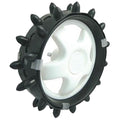 A circular toy wheel with a white inner hub is surrounded by a black outer ring featuring multiple protruding spikes designed for traction on surfaces like sand or grass.