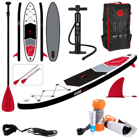 A paddleboard kit features a large paddleboard with a red and black design a pump a backpack paddles wheel leash and repair kit set up against a neutral background