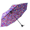 A purple umbrella adorned with colorful hearts is open and tilted to one side showcasing its vibrant pattern against a plain background providing shade or protection from the elements.