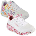 Colorful white sneakers featuring heart designs along the sides and soles are positioned together with laces untied in a bright and cheerful setting. Brand name Skechers is visible on the shoe.