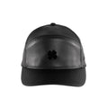 A black cap features a shiny black four-leaf clover emblem on the front with a smooth leather texture blending into a structured bill and a minimalist design suitable for casual wear.