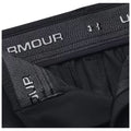 Black athletic shorts are displayed closely showing the waistband with "UNDER ARMOUR" branding on the front and a soft fabric texture around the edges in a neutral setting.