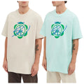 Two men are wearing oversized graphic t-shirts in beige and light blue each displaying a colorful logo with overlapping circles and lines in a casual setting.