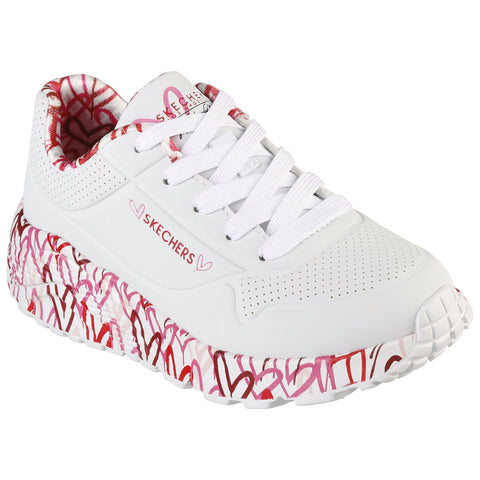 A white sneaker features a textured upper and a thick sole adorned with pink and red scribbled heart designs while laces are securely fastened conveying a playful and vibrant aesthetic.