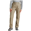 Light khaki pants are worn by a person standing with one hand resting on their thigh in an outdoor setting wearing a long-sleeve gray shirt and hiking boots.