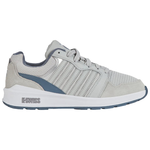 A gray athletic shoe with a mesh and suede design rests on a flat surface showcasing its prominent laces and branding while emphasizing comfort and style for active wear.